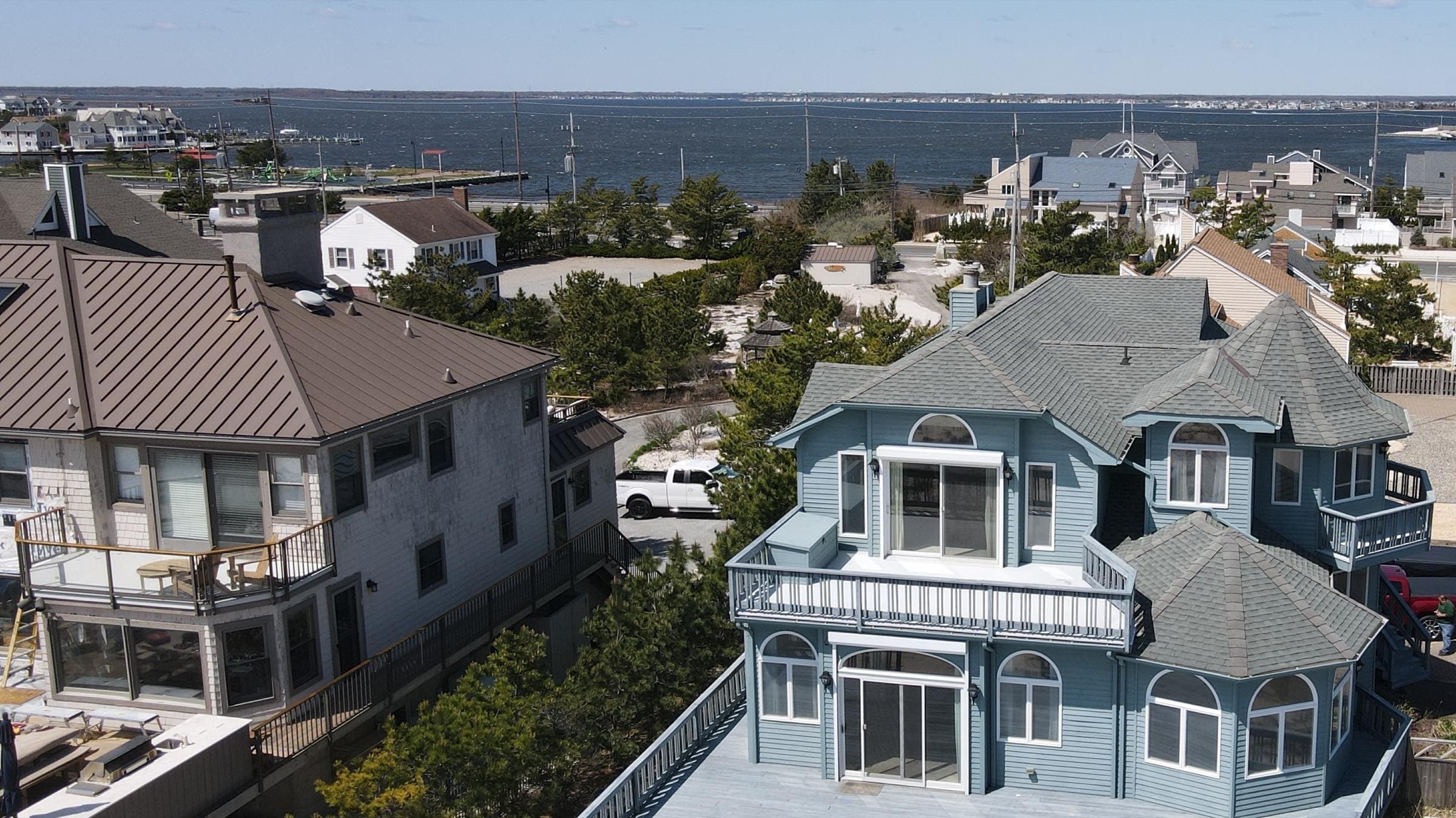 A New Jersey shore home seen from the air, with the bay behind it